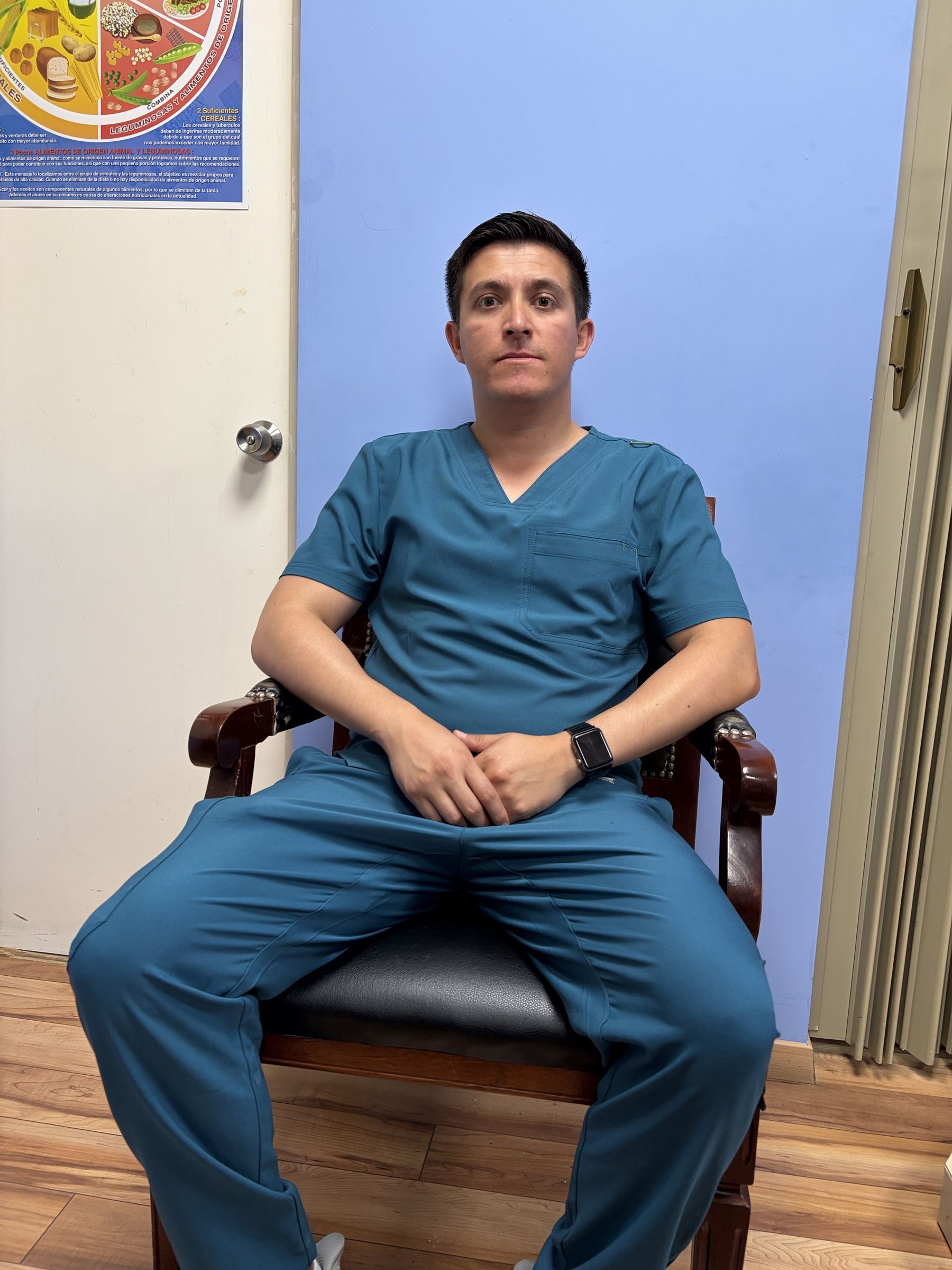 Dr. Alexis Quintanar sentado en su consultorio